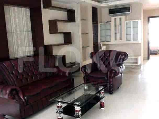 Elegant living room with leather sofa, armchair, and glass coffee table.
