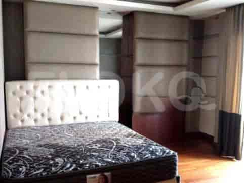 Bedroom with a tufted headboard and a patterned bedspread.