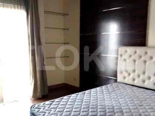 Bedroom with a bed, shelves, and a balcony entrance.