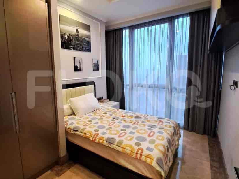 Kamar tidur dengan tempat tidur ganda, karya seni, dan lemari geser.