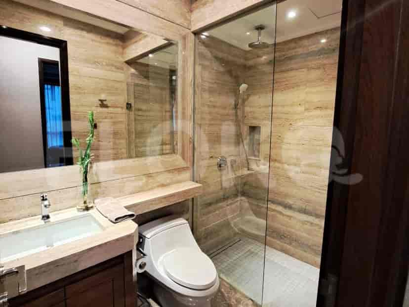 Kamar mandi modern dengan wastafel, toilet, dan pancuran walk-in.