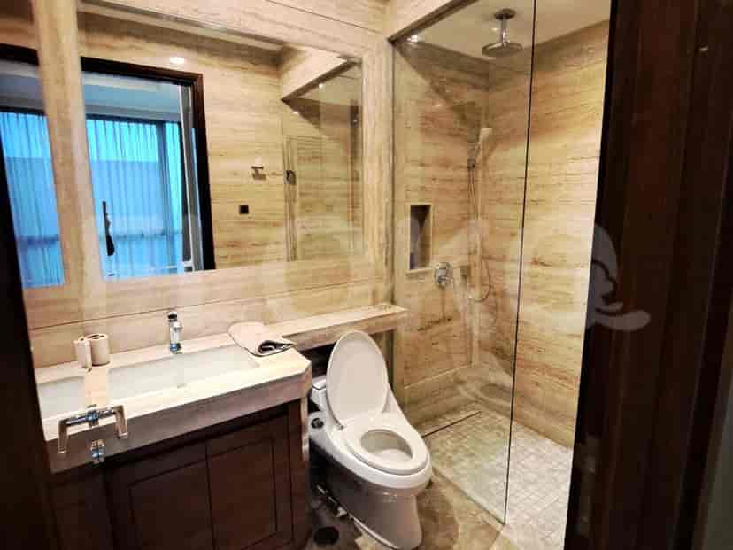 Kamar mandi modern dengan wastafel, toilet, dan pancuran walk-in.