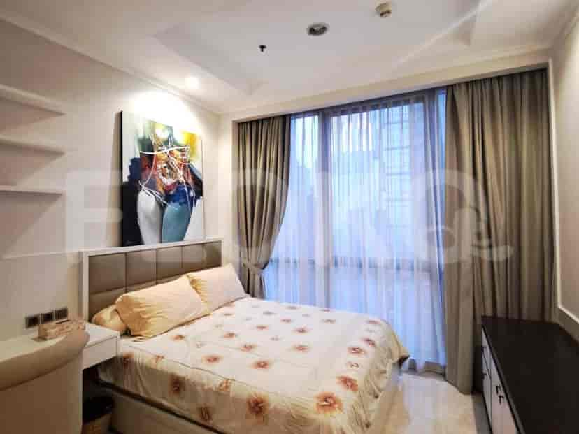 Kamar tidur bergaya dengan tempat tidur, karya seni, dan gorden tipis.