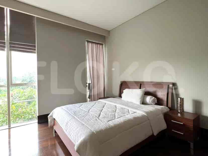 Bedroom with a wooden bed, nightstand, and large window.