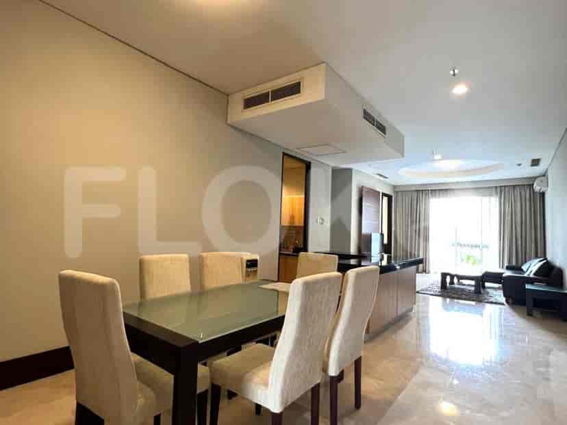Dining area with a glass-top table, chairs, and adjacent kitchen space.