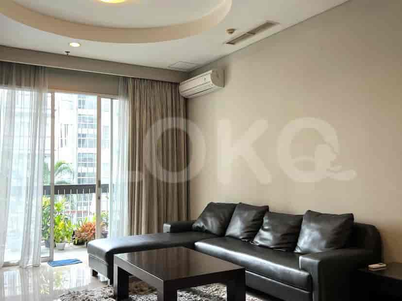 Spacious living room with an L-shaped leather sofa, coffee table, and large windows.