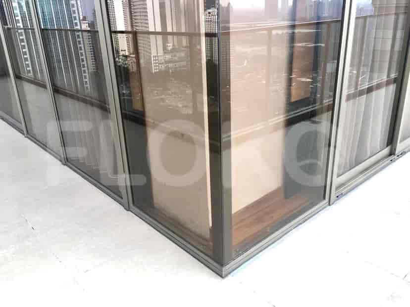 A balcony with glass panels and a view.