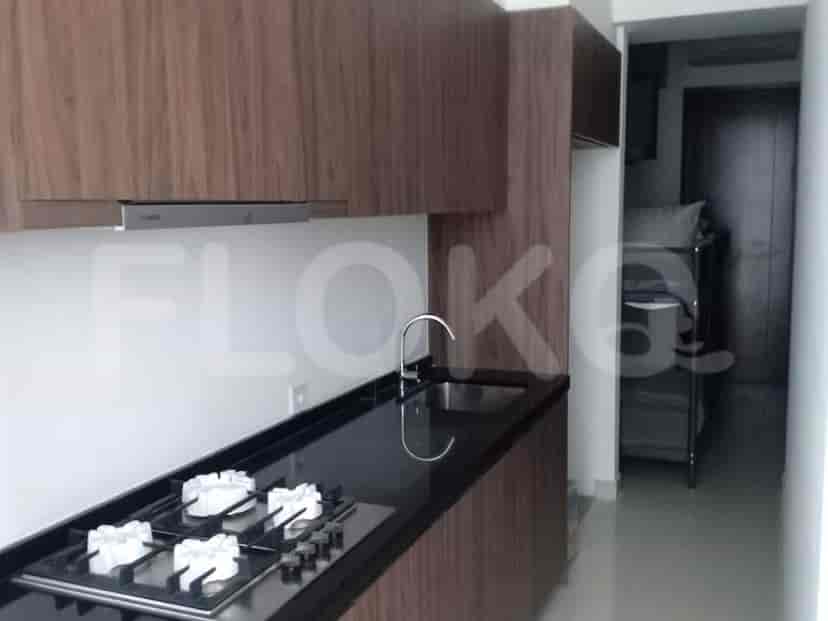 A kitchenette with cabinets, a sink, and a gas stove.