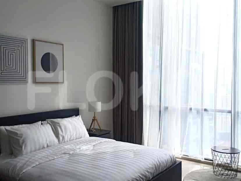 A bedroom with a bed, artwork, and curtains.