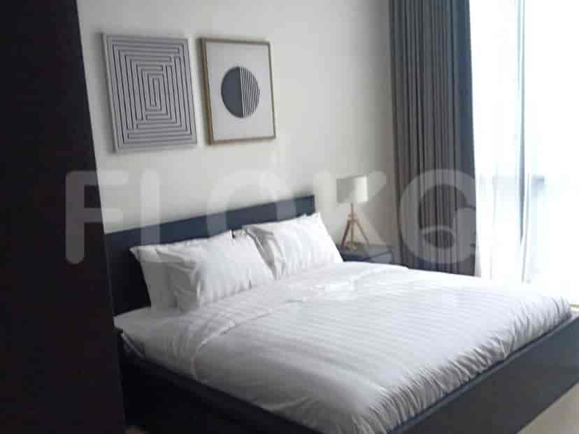 A bedroom with a bed, artwork, and curtains.