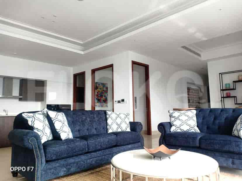 A living room with two blue sofas, a coffee table, and a view of the interior doors.
