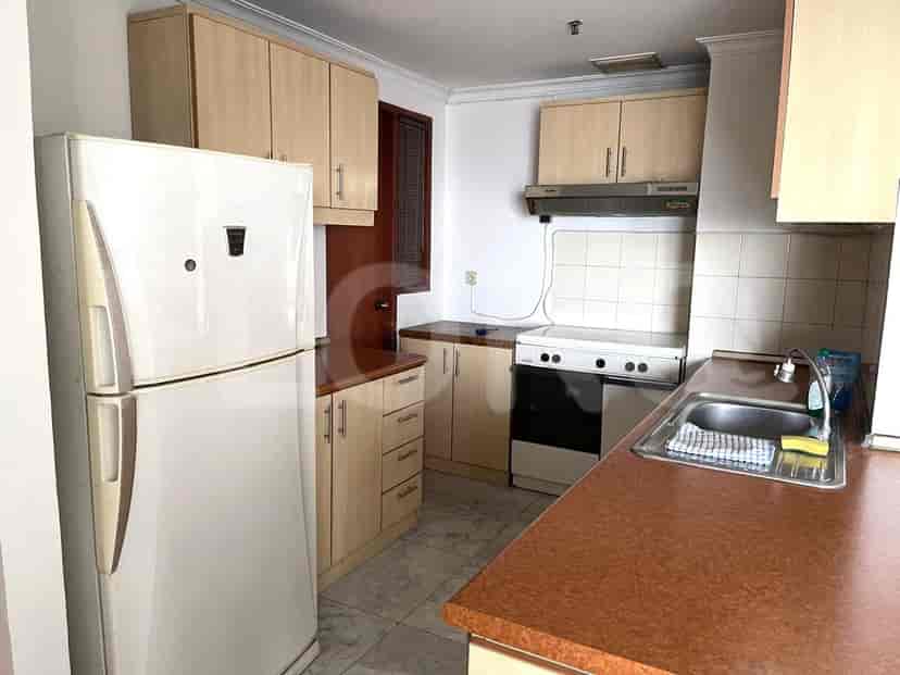 Dapur dengan lemari kayu, peralatan, dan meja.