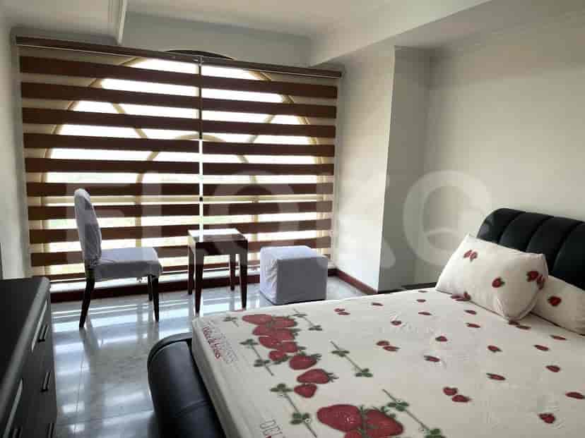 Kamar tidur dengan jendela besar, tempat tidur, dan tirai dekoratif.