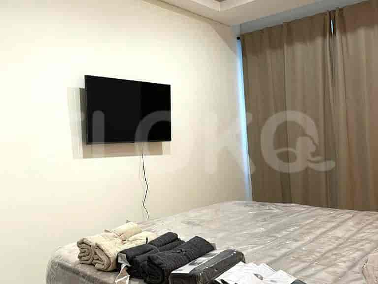 Bedroom with a bed, wall-mounted TV, and curtains.