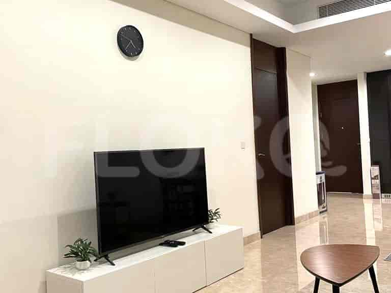 Living room with TV, sofa, and a clock.