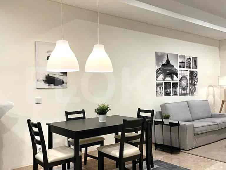 Dining area with dining table and chairs, and a hanging light fixture.