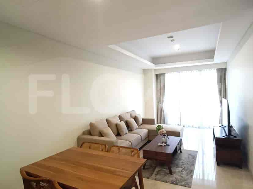 Living room with a beige L-shaped sofa, TV, wooden table, and a dining area.