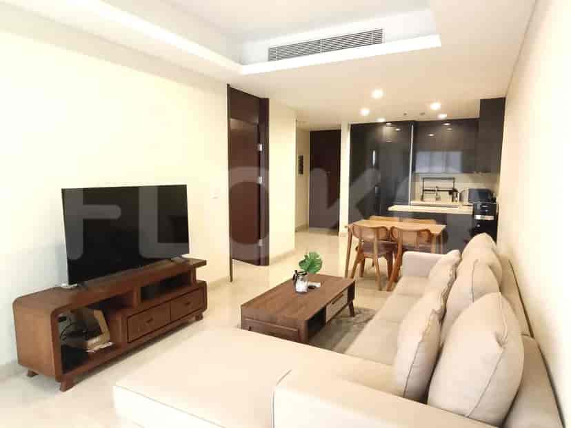 Open-plan living and kitchen area, with a sofa, kitchen cabinets, and a dining table.