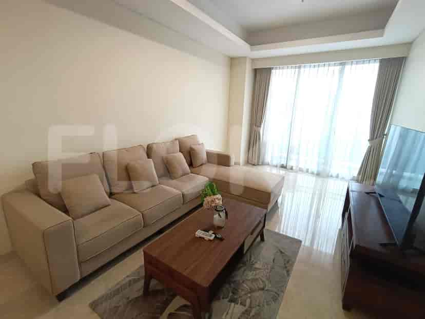 Living room with a beige L-shaped sofa, coffee table, and large windows.