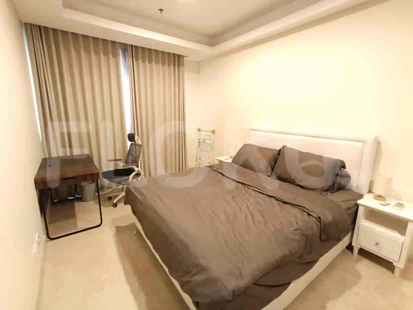 Bedroom featuring a queen-size bed, desk, and curtains.