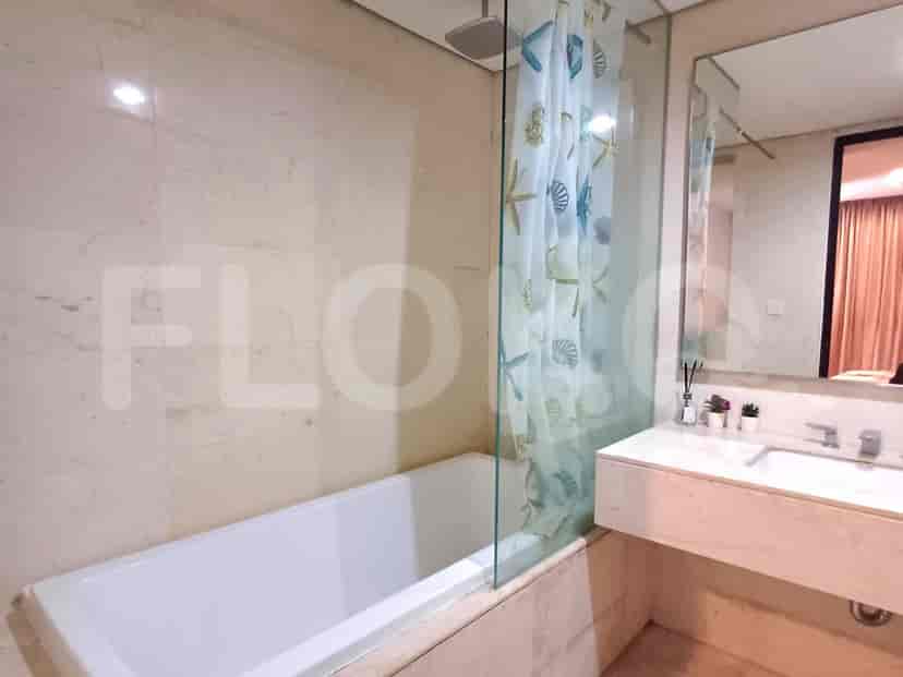 A bathroom with a bathtub, shower curtain, and marble walls.