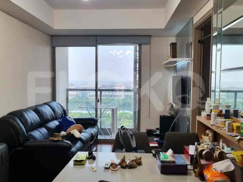 Spacious living room with a black sofa, dining table, and a view of the city.