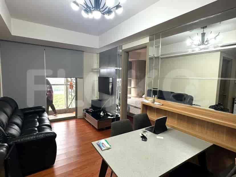 A well-lit living room with a leather sofa, a dining table, and a balcony.