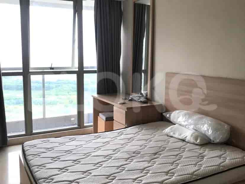 Another bedroom view showing a bed, a mirror, and a desk area.