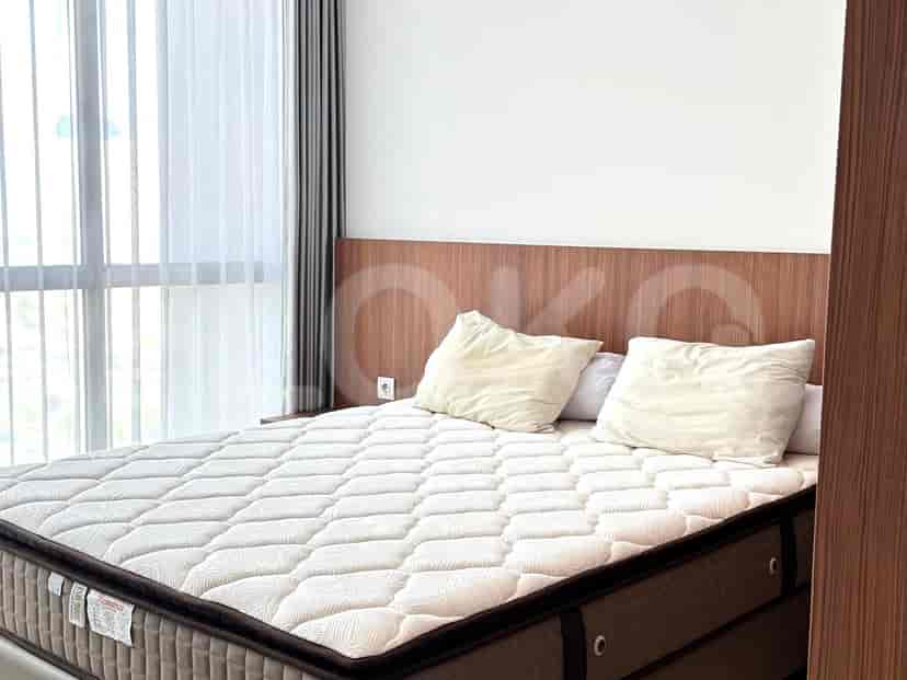 A bedroom with a bed and large windows.