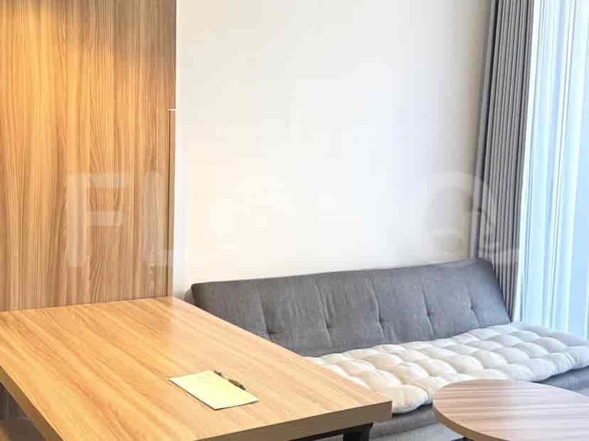 A compact living space with a sofa, table, and a desk.