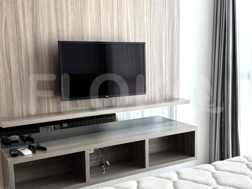 A living room with a television and wooden accent paneling.
