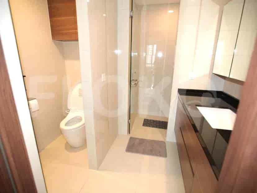 A modern bathroom with a toilet, shower and sink.