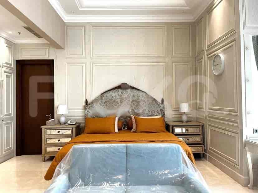 Kamar tidur bergaya dengan tempat tidur, meja samping tempat tidur, dan sofa biru muda.