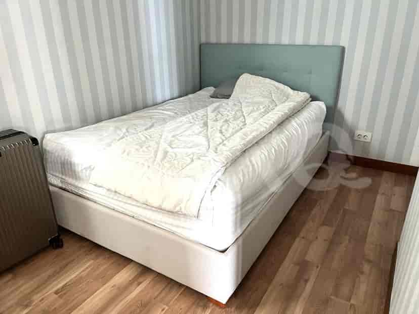 Small bedroom with a single bed, a bedside table, and a striped wall.
