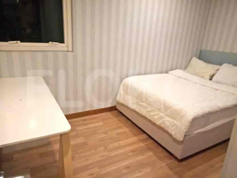 Bedroom with a bed, desk, and a striped wall.