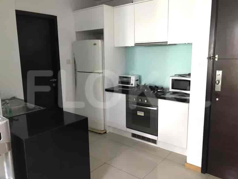 A modern kitchen with a refrigerator, microwave, and stovetop.