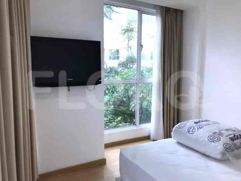 A bedroom with a window and TV.