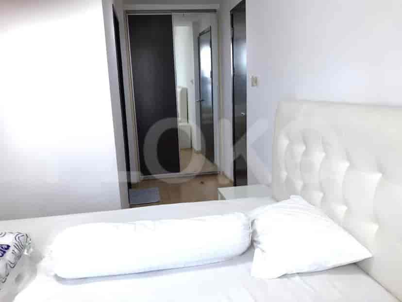 The bed, showing a mirrored closet entrance.