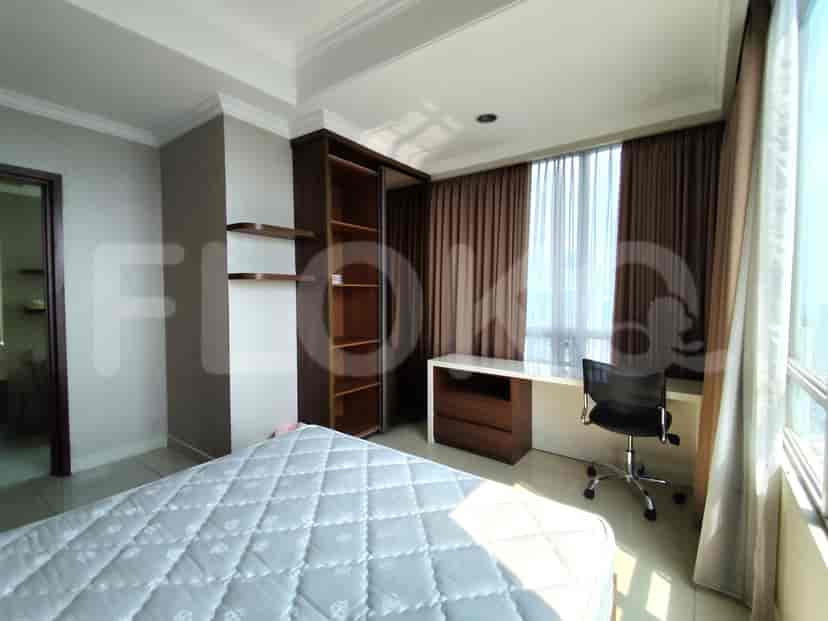 Bedroom with a bed, desk with a black chair, and a large window.