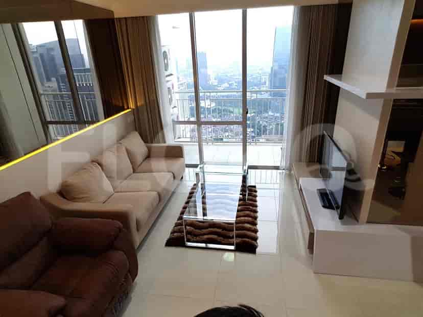 Another angle of the living room, showcasing the sofa, glass table, and large windows.