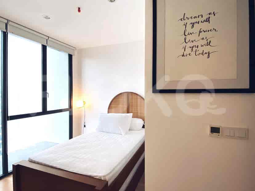 A bedroom with a bed, a picture and a window.