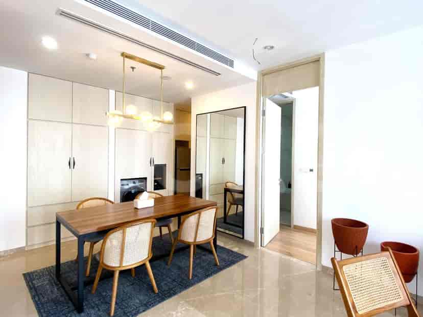 Dining space with a wooden table, chairs, and a view of the living area through an open doorway.
