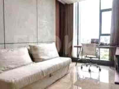 A small office/study area with a sofa and a work desk overlooking a city view.