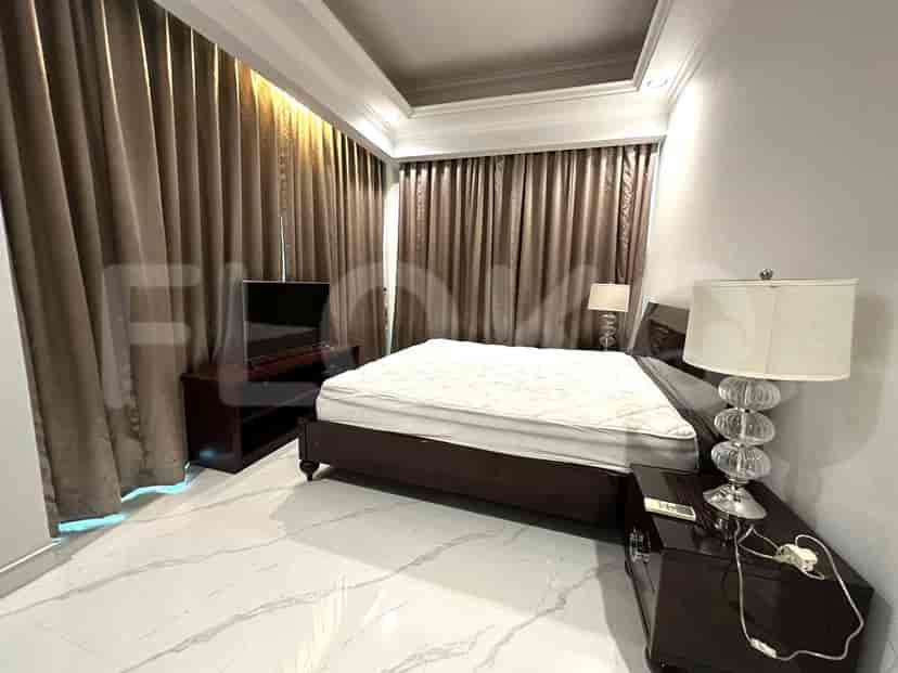 A bedroom with a bed, curtains, and a television.