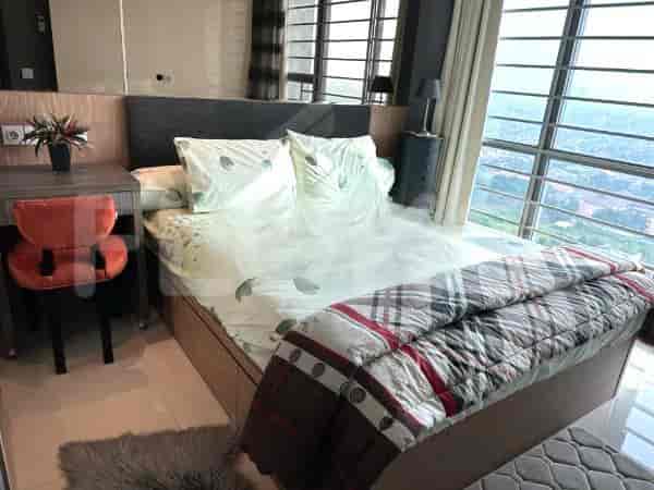 Kamar tidur yang terang benderang menampilkan tempat tidur, meja, dan jendela besar.