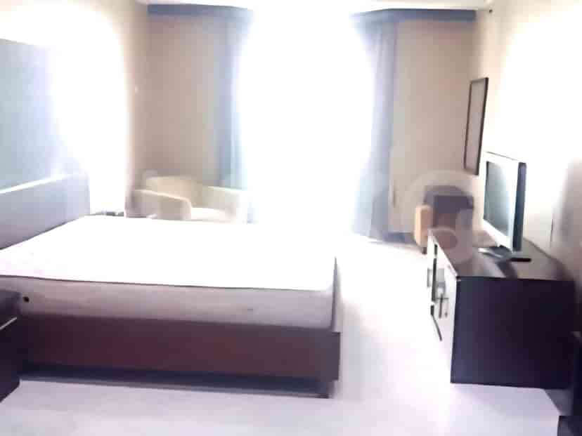 A bedroom with a bed and TV.