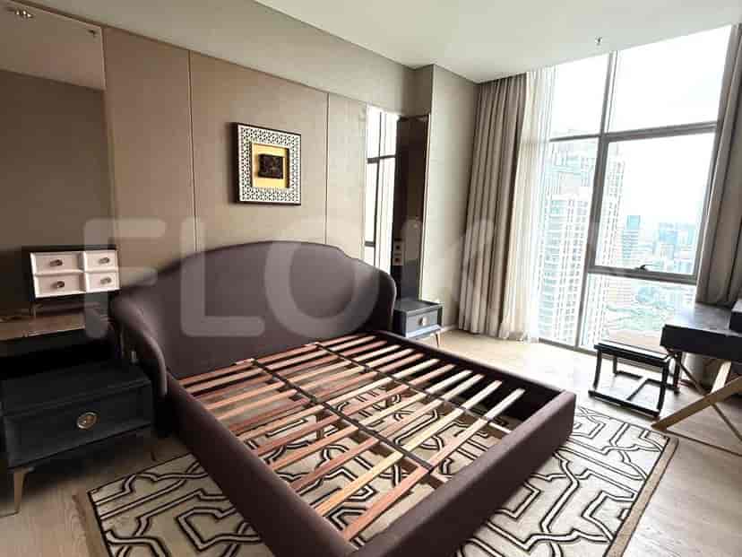 Kamar tidur dengan tempat tidur besar, meja samping tempat tidur, dan pemandangan kota.