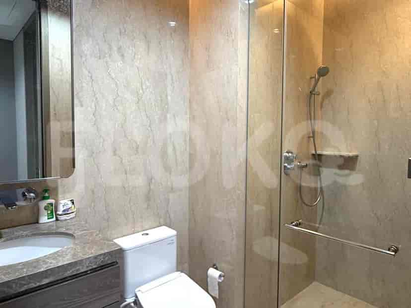 Kamar mandi dengan pancuran kaca dan finishing marmer.