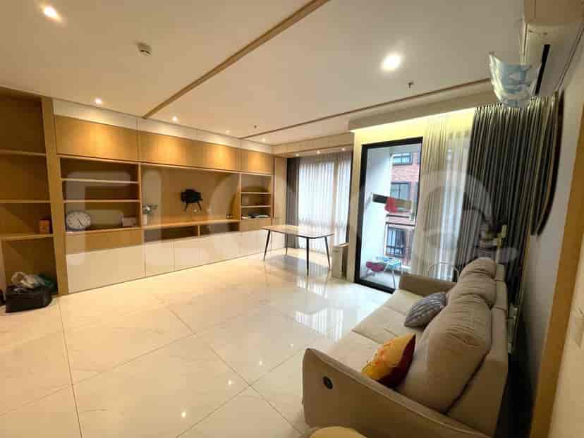 Bright and modern living room with a beige sofa, white tiled floor, and large built-in storage.