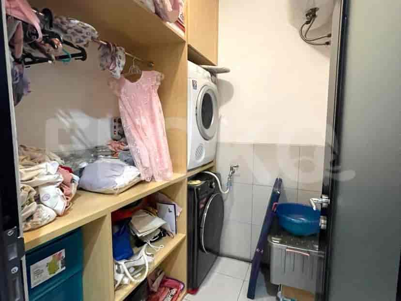 Utility room with a washing machine, dryer, and storage.